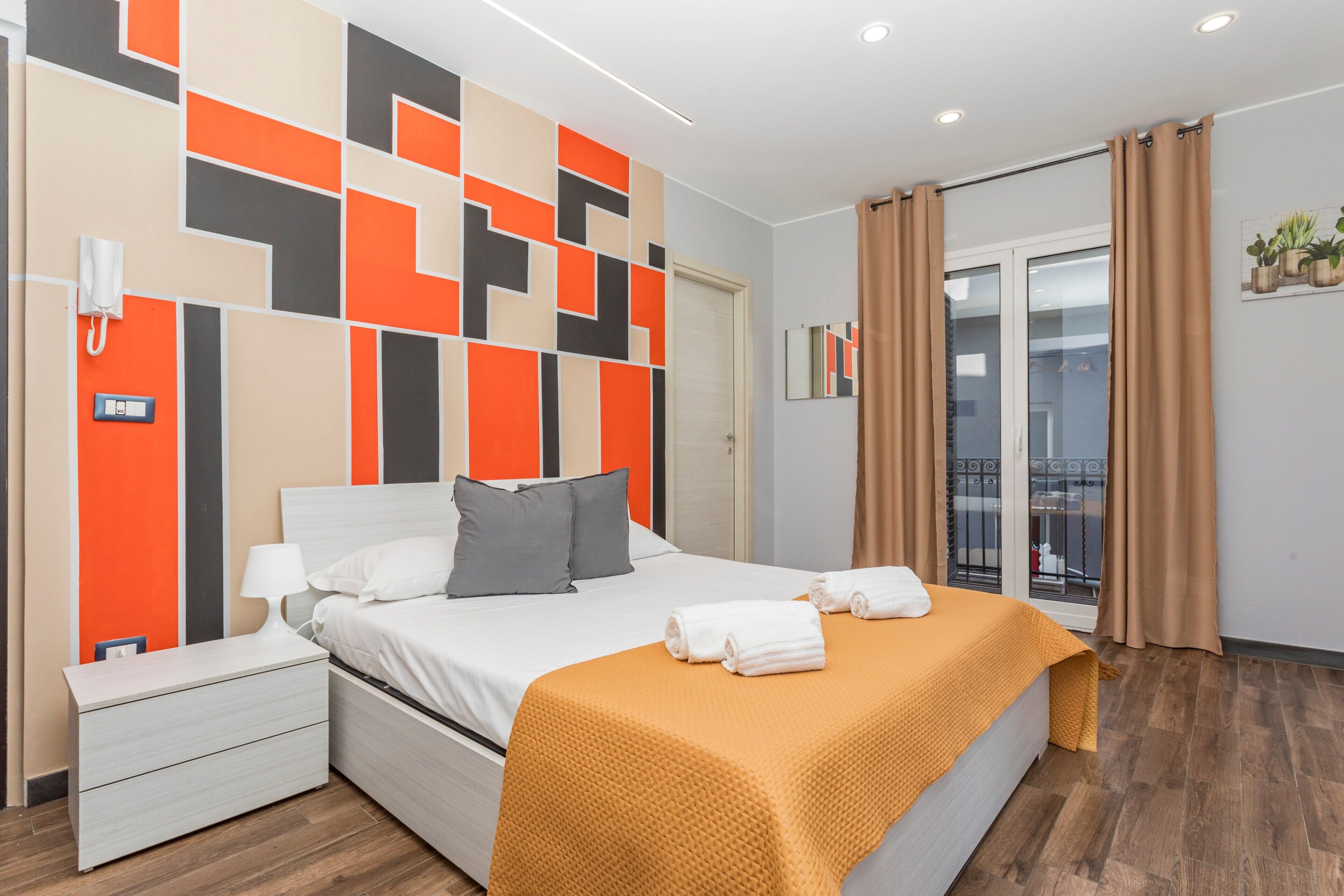 Ein modernes Hotelzimmer mit Bett, Nachttisch und Blick ins Freie.