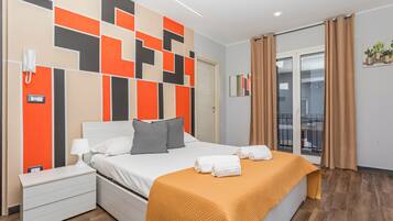 Ein modernes Hotelzimmer mit Bett, Nachttisch und Blick ins Freie.