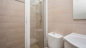 Ein Badezimmer mit Dusche, Toilette und Waschbecken.