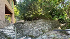 A stone staircase leading up to a building with a green roof. - Flowery villa: family home, veranda and garden (Tende)