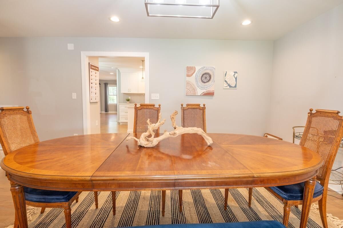 A dining room with a large wooden table, four chairs, and a unique centerpiece.
