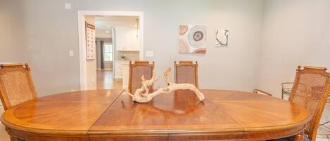 A dining room with a large wooden table, four chairs, and a unique centerpiece.