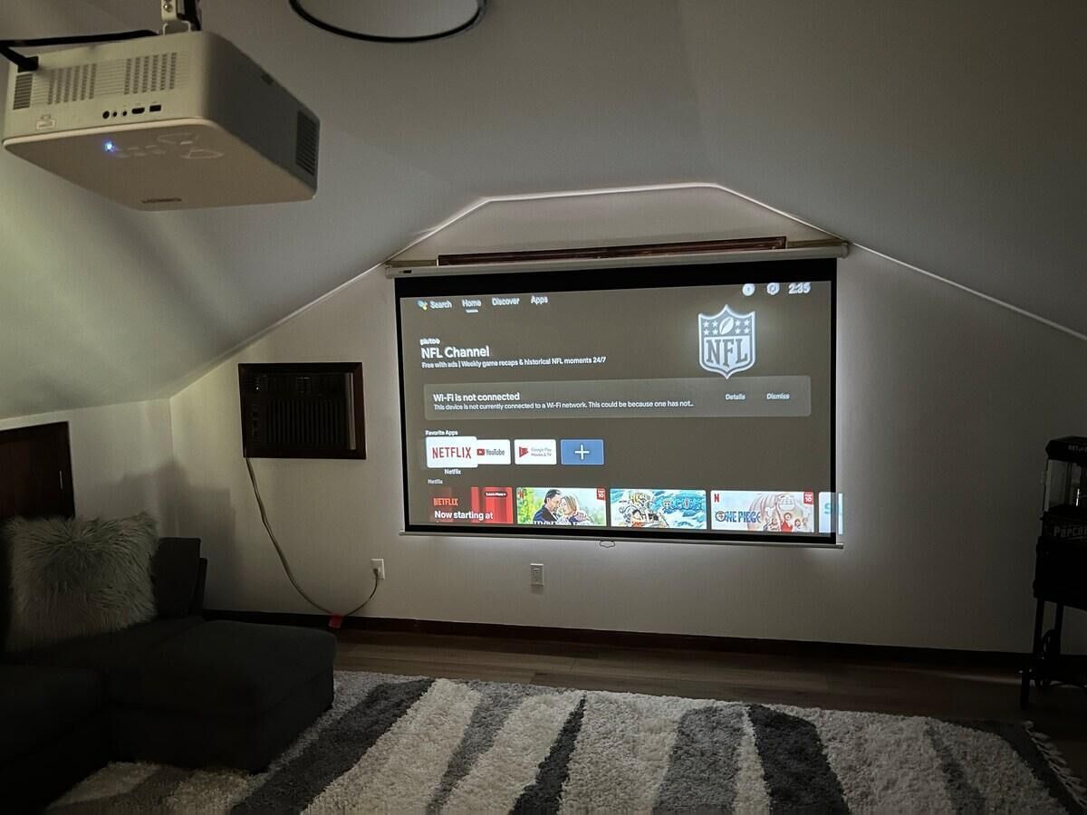 A home theater setup with a large screen displaying the NFL Channel and Netflix interface.