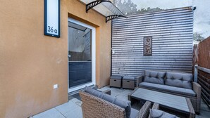 A patio with wicker furniture, a wooden wall, and a number sign '36a'. - Apartment 'Backstuff' with Wi-Fi (Hambuch)