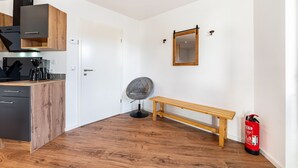 A kitchen with wooden cabinets, a bench, a chair, and a fire extinguisher. - Apartment 'Backstuff' with Wi-Fi (Hambuch)