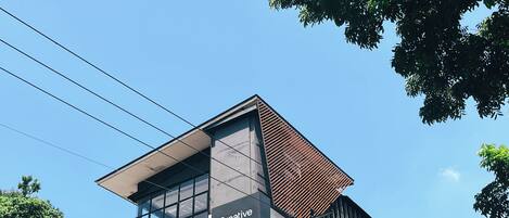 A modern building with a prominent 'Creative Rest' sign, large windows, and a mix of glass and metal construction.