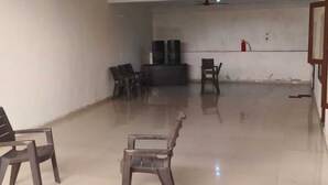 Una habitación amplia con techo alto, un ventilador de techo y algunas sillas.