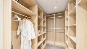 Un armario vestidor con estantes de madera, una barra para colgar ropa y una alfombra gris.