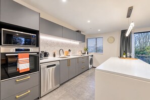 A modern kitchen with stainless steel appliances, a dishwasher, and a large island.