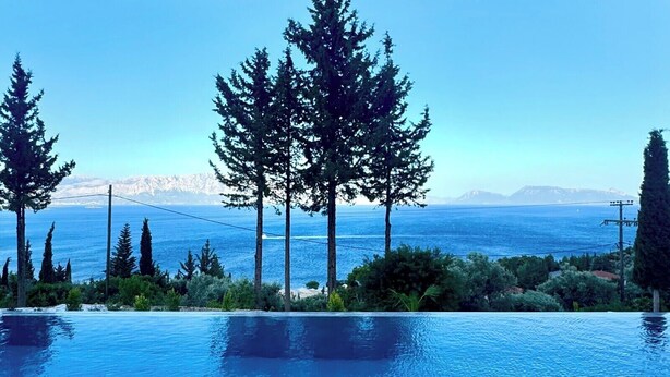 An infinity pool with a view of the sea and mountains.