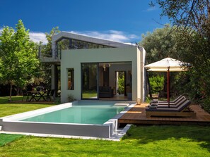A modern house with a swimming pool, outdoor furniture, and a garden. - Peaceful Cosy Modern villa w/t private pool,close to town & beach (LEFKADA)