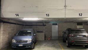 Eine Parkgarage mit zwei Autos, die in nebeneinanderliegenden Stellplätzen 13 und 14 geparkt sind.