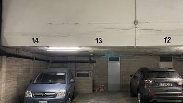 Een parkeergarage met twee auto's geparkeerd in aangrenzende parkeerplaatsen, genummerd 13 en 14.