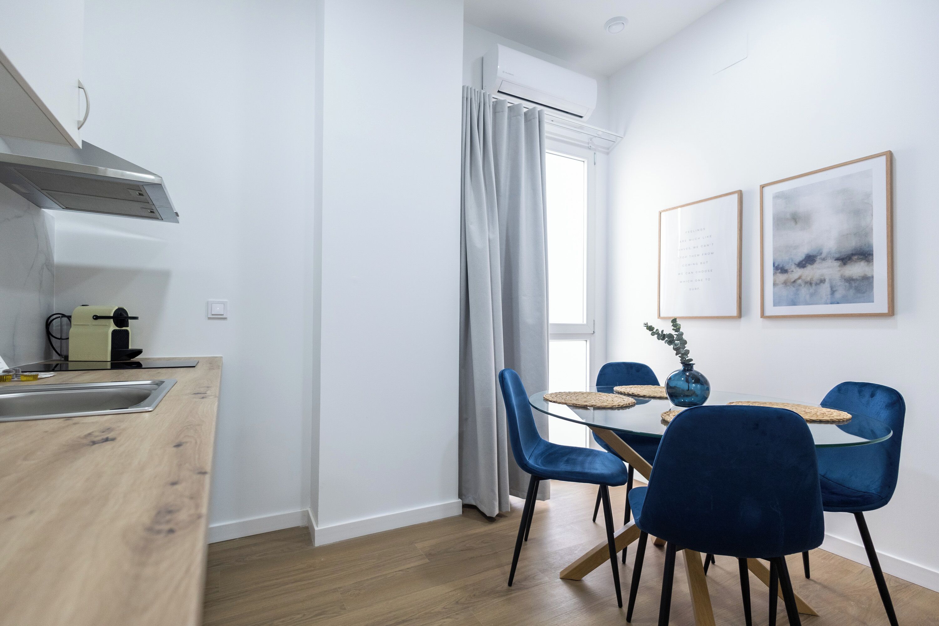 Una cocina moderna con estufa integrada, un lavamanos y una ventana con cortinas.