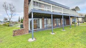 A modern two-story building with a covered patio area, large windows, and a brick facade.