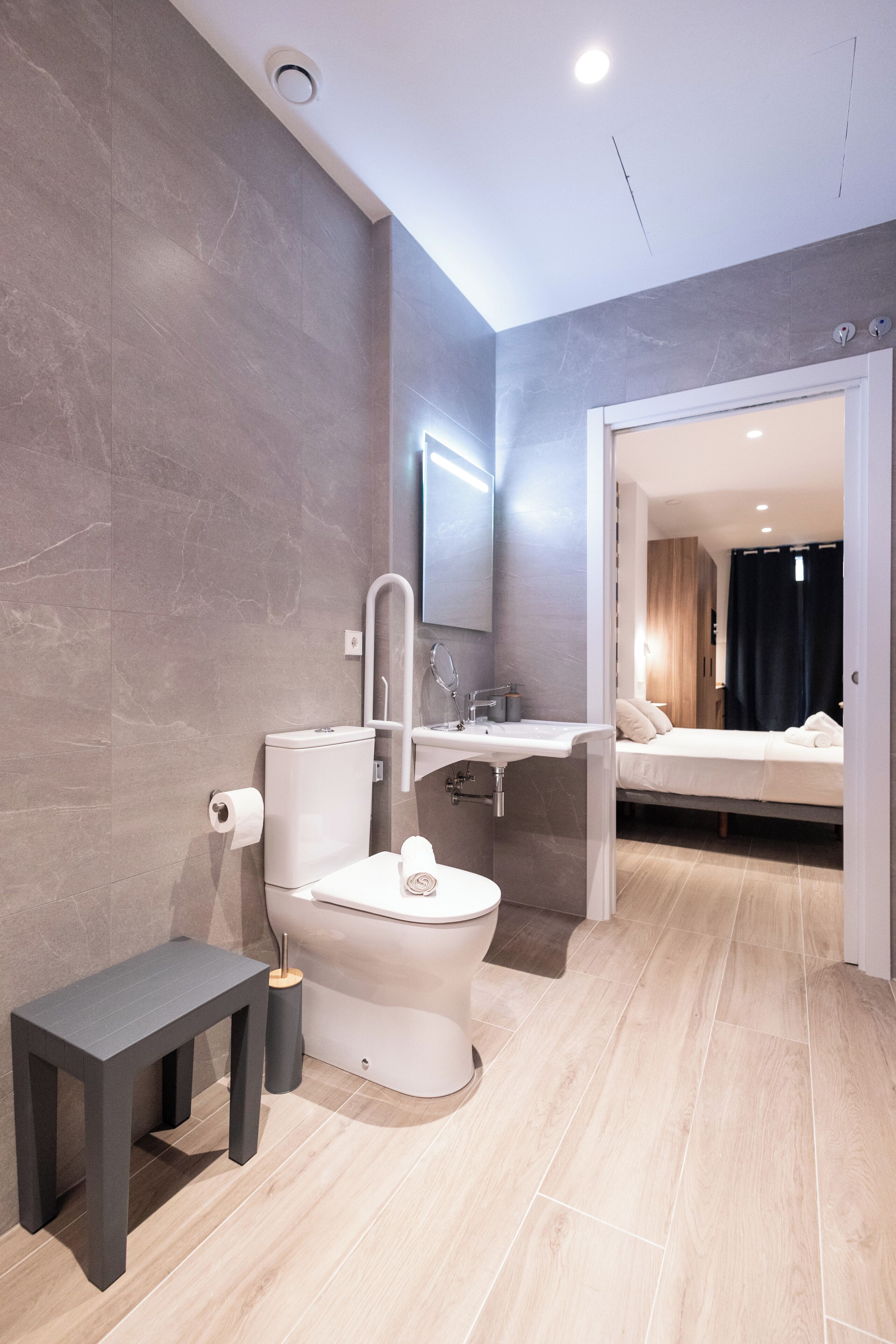 Un baño moderno con inodoro, lavamanos y banco.