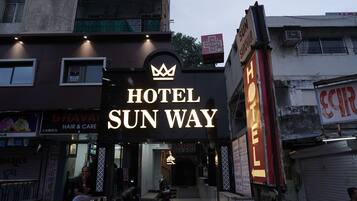 A hotel sign with a crown logo and the name "HOTEL SUN WAY".
