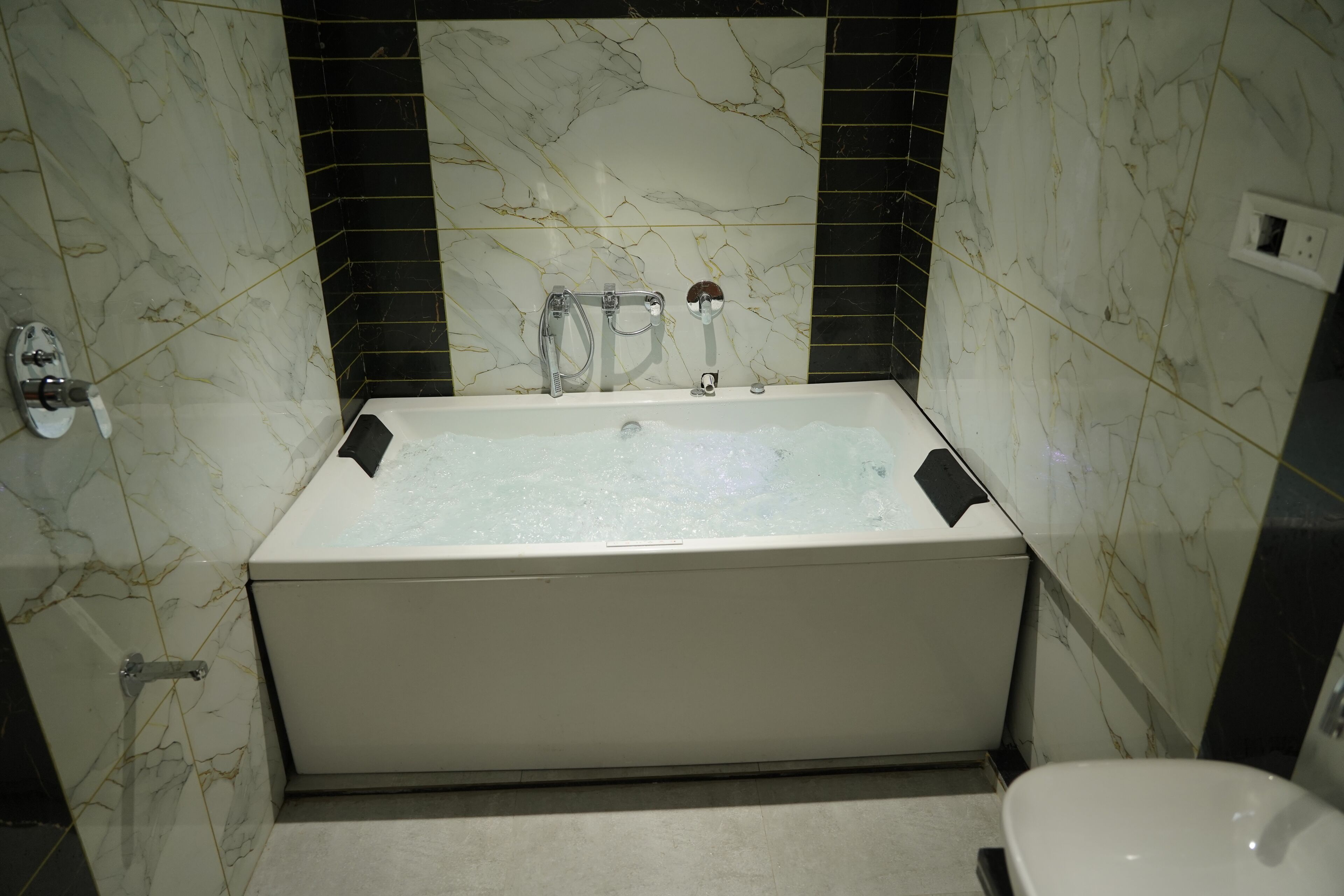 A bathroom with a bathtub, a toilet, and a shower area.