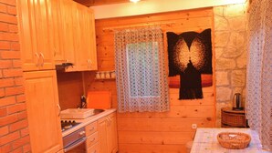 A cozy kitchen with wooden cabinets, a stove, and a dining area with a table and chairs.