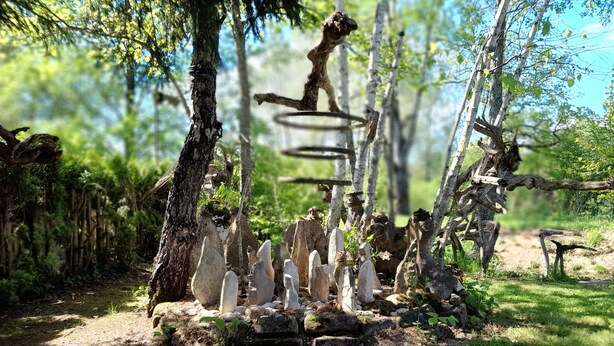 A rustic outdoor setting with a stone structure surrounded by trees.