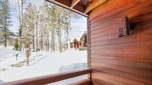 A wooden cabin with a view of a snowy forest and a clear sky. - Cozy Highridge Condo Unit I6 in Killington with pool and hot tub. (Killington)