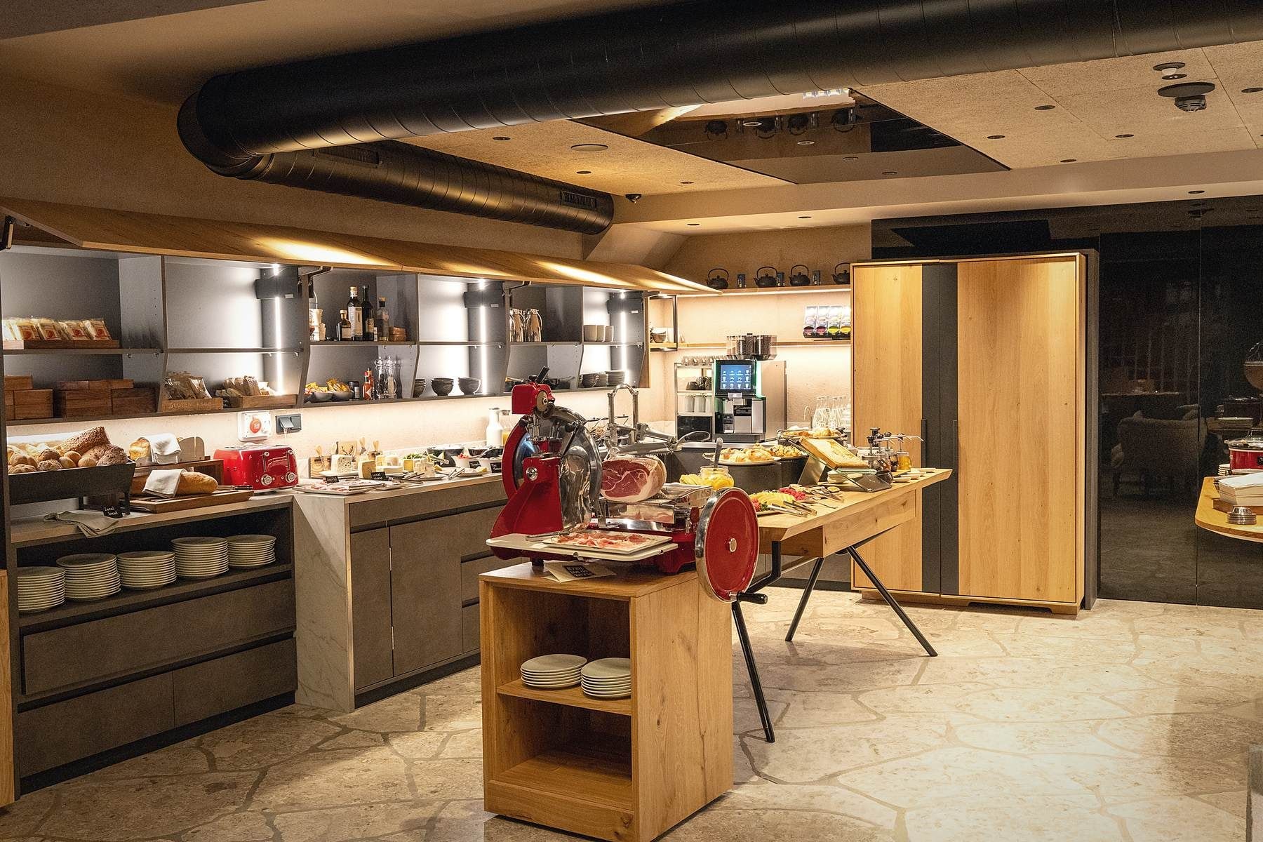 A modern kitchen with a central island, various appliances, and a seating area.