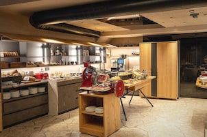 A modern kitchen with a central island, various appliances, and a seating area.