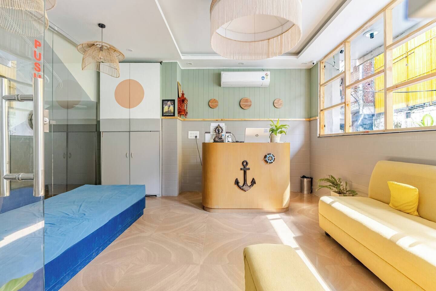 A modern hotel lobby with a reception desk, a blue sofa, and a yellow couch.
