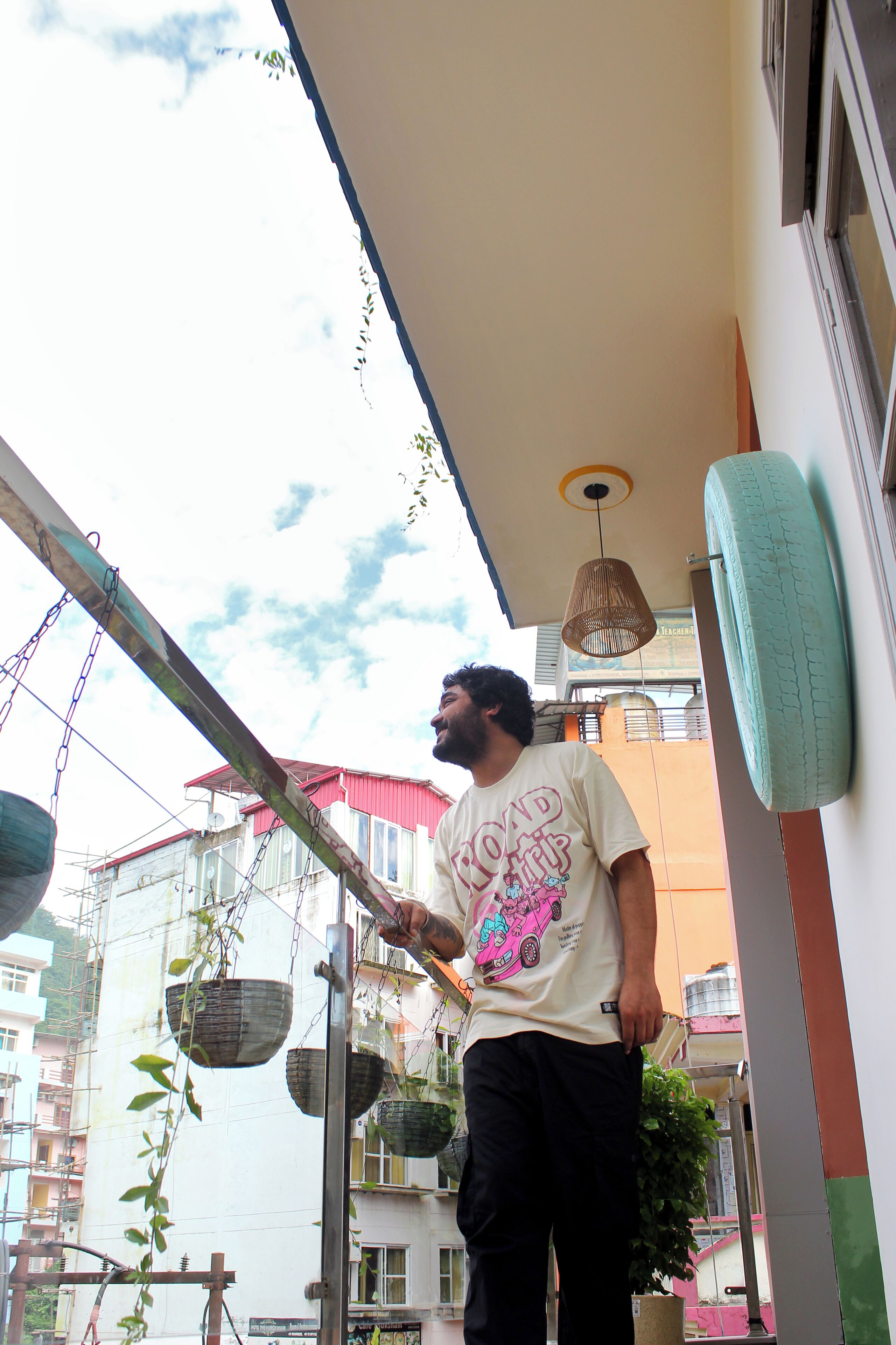 A balcony with hanging baskets and a hanging light fixture.