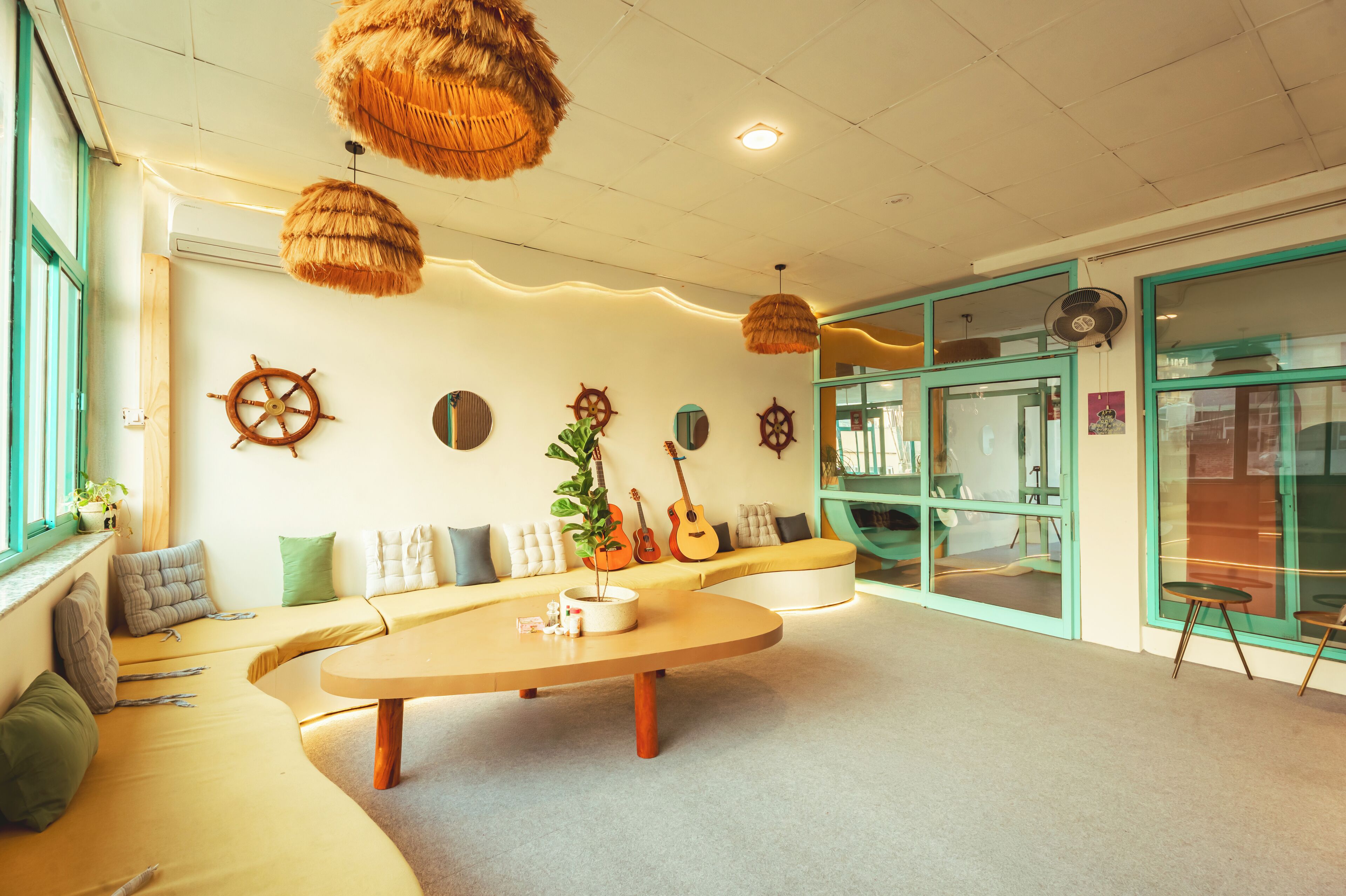 A modern interior with a curved sofa, a round coffee table, and decorative wall elements like ship wheels.