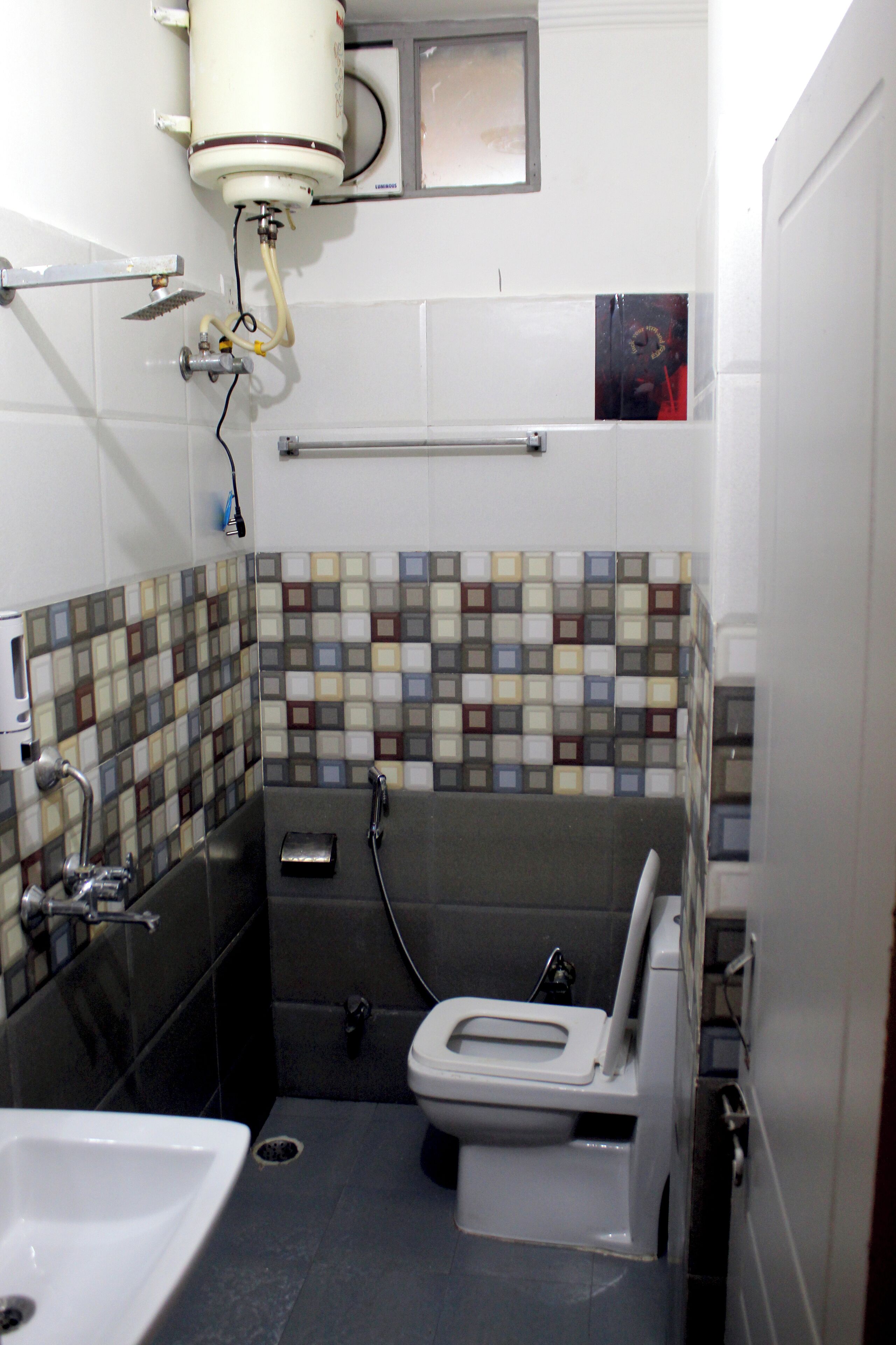 Un baño pequeño con inodoro, lavamanos y ducha.