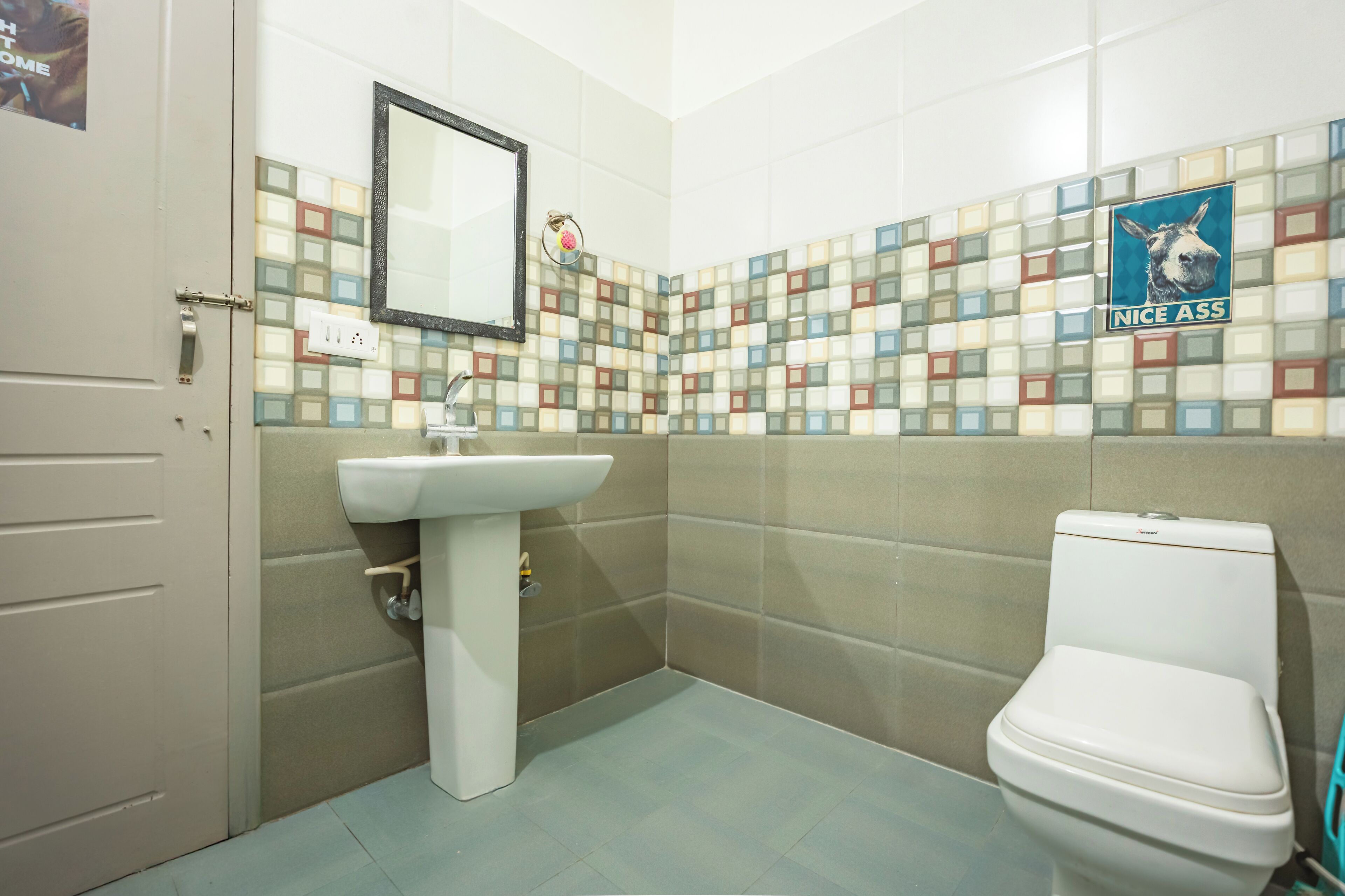 A bathroom with a tiled backsplash, a sink, and a toilet.