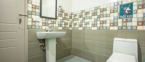 A bathroom with a tiled backsplash, a sink, and a toilet.