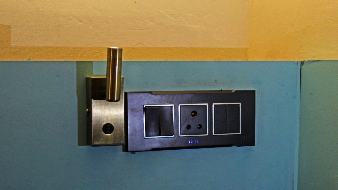 A wall-mounted electrical outlet with a switch and three sockets.