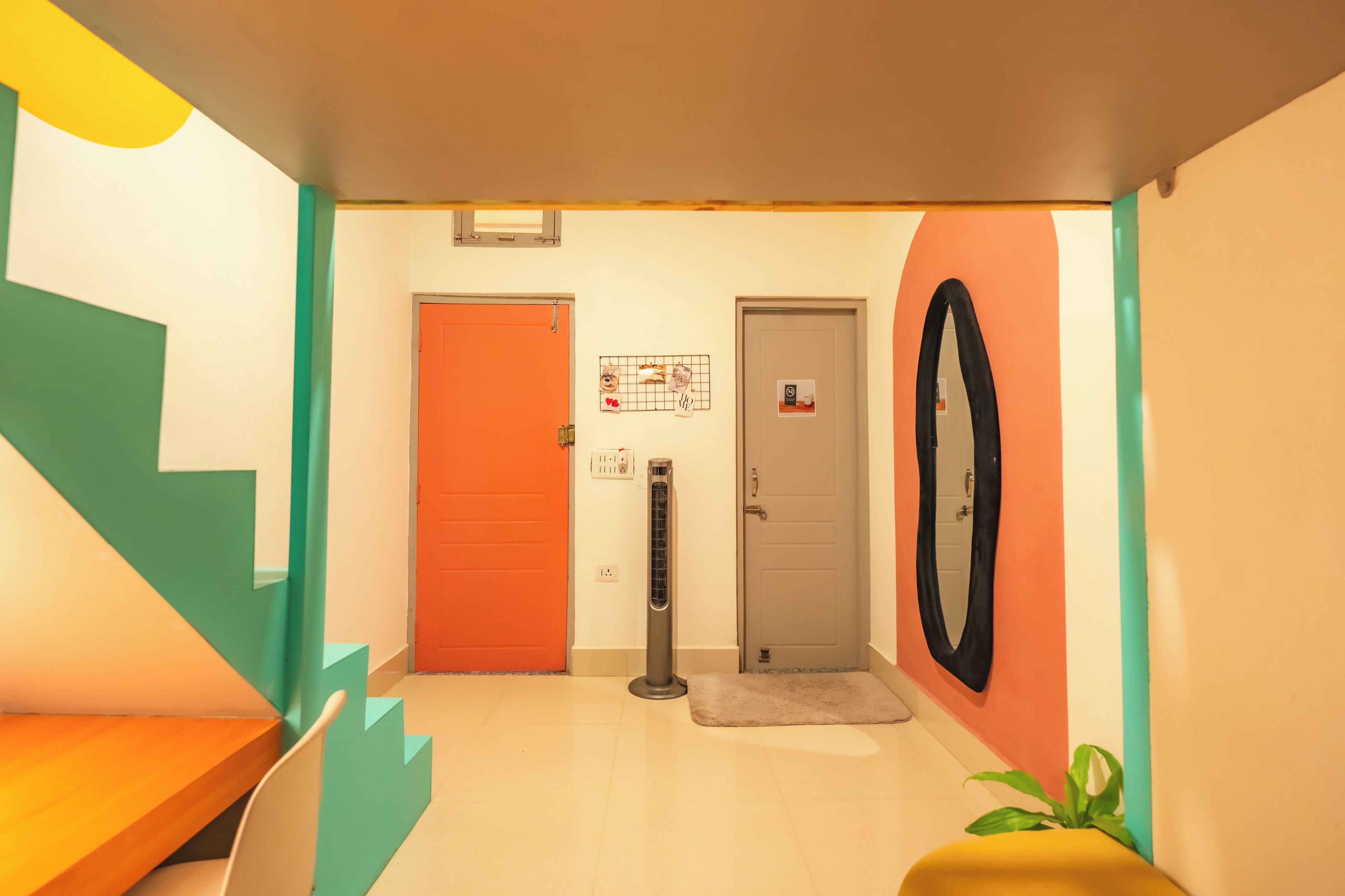 Un intérieur moderne avec un escalier, un radiateur, une porte et un miroir.