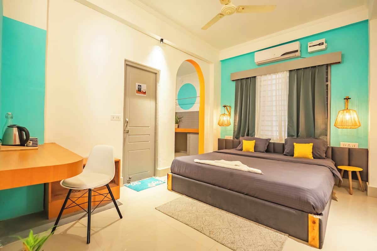 Une chambre d’hôtel moderne équipée d’un lit, d’un bureau, d’une chaise et d’une petite table d’appoint.