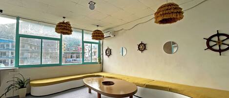 A room with a curved bench, a round table, and nautical-themed wall decorations.