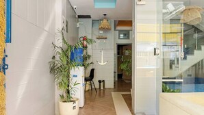 A modern hallway with a wooden floor, a glass door, and a potted plant. - Hostel De Offlanders Rishikesh • Stay • Connect • Explore (Rishikesh)