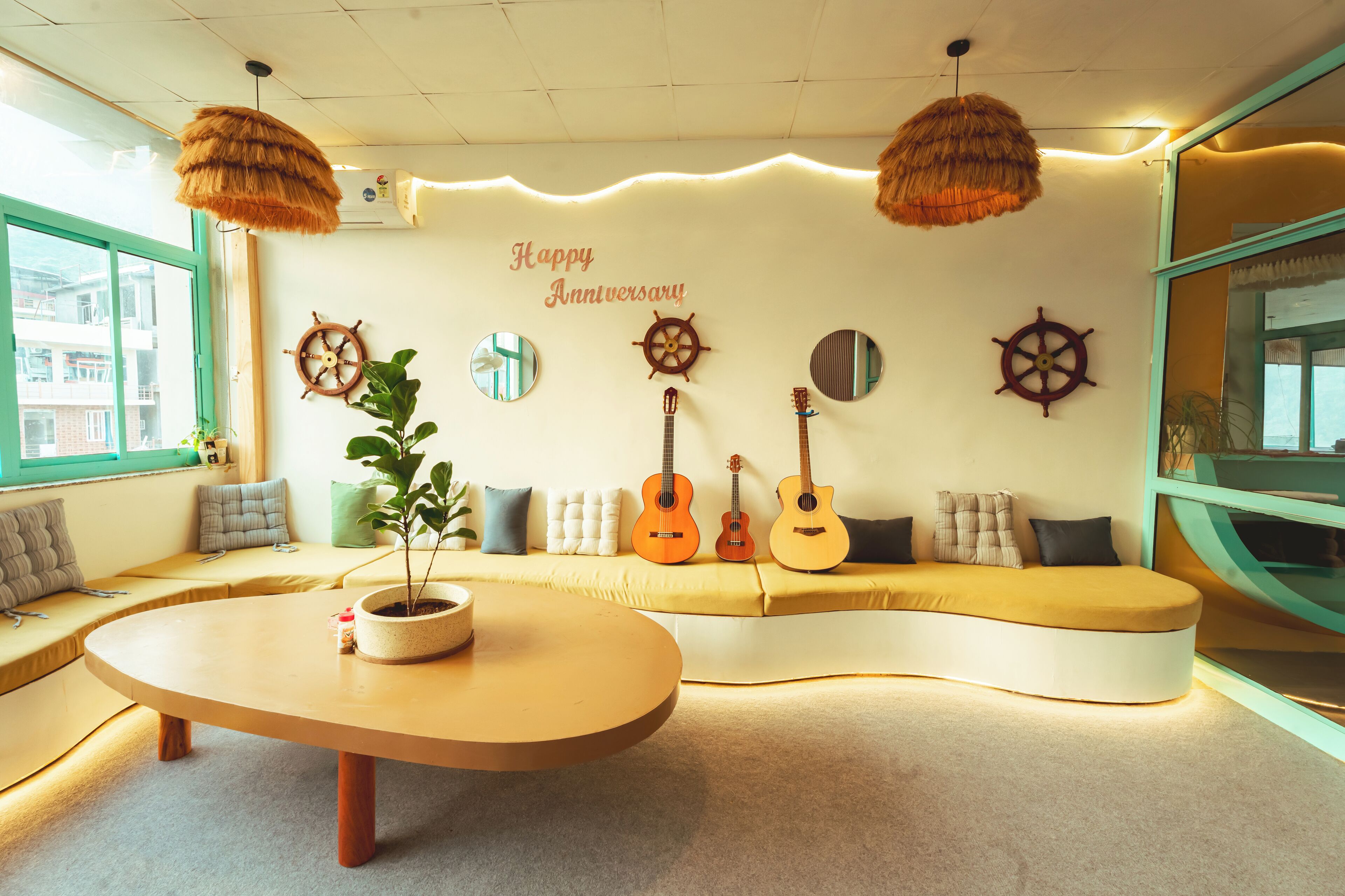 A cozy living area with a curved sofa, a round coffee table, and three guitars.