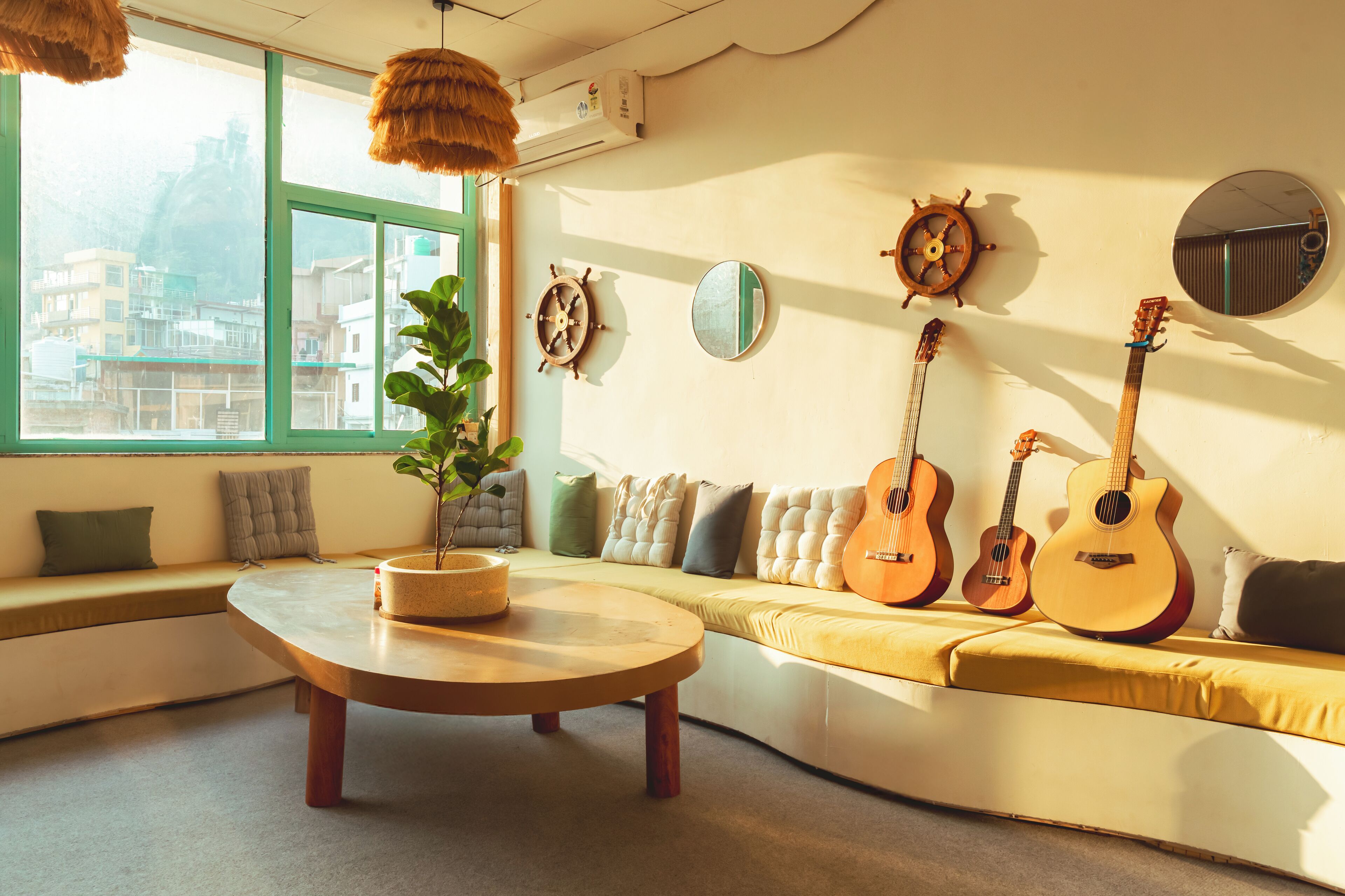 A cozy room with a curved sofa, a round coffee table, and three guitars against the wall.
