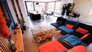 A modern living room with a sofa, coffee table, and dining area.