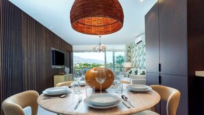 A modern dining area with a round table, chairs, and a large vase centerpiece.