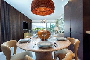 A modern dining area with a round table, chairs, and a large vase centerpiece.