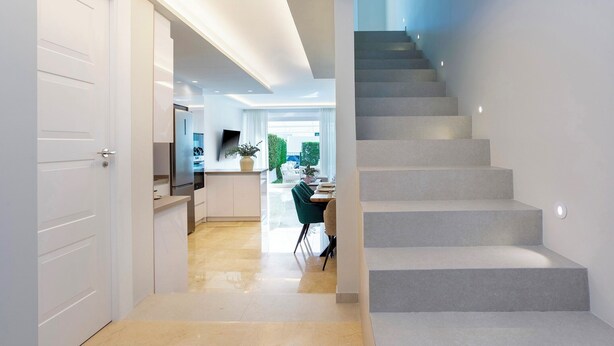 A modern interior with a staircase, a kitchen area, and a dining space. - Magnificent 3BD Duplex With Pool. Aloha Golf II (Marbella)