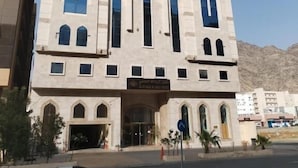 A multi-story building with large vertical windows and a central entrance. - Al Resala Al Masi Hotel (Makkah)