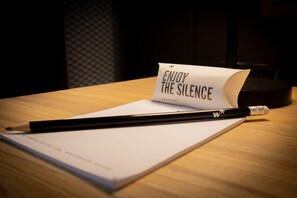 A desk with a notepad, a pencil, and a card that reads "ENJOY THE SILENCE CARPLUGS." - w Scenic 1BR w Terrace in Barranco (Lima)
