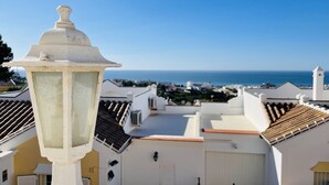 Un bâtiment blanc, doté d’un toit recouvert de tuiles et offrant une vue sur la mer.