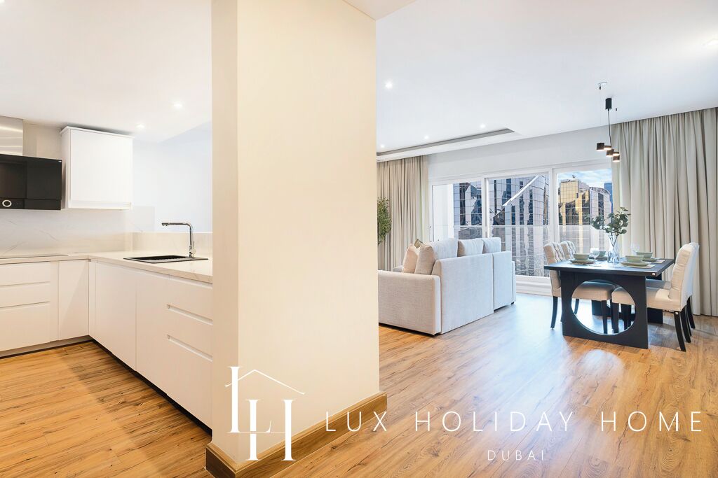 A modern kitchen with white cabinets and a dining area with a table and chairs.