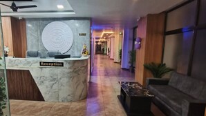 A reception area with a marble counter, a sofa, and a coffee table.
