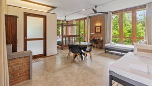 A spacious room with a large window, a dining area, and a massage table. - Ko Lake Villa Rooms lakeside Beach (Koggala)